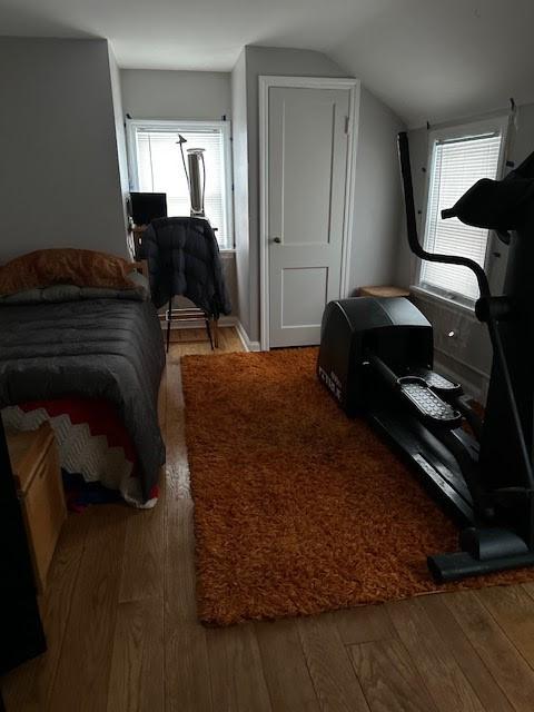 bedroom with hardwood / wood-style flooring and vaulted ceiling