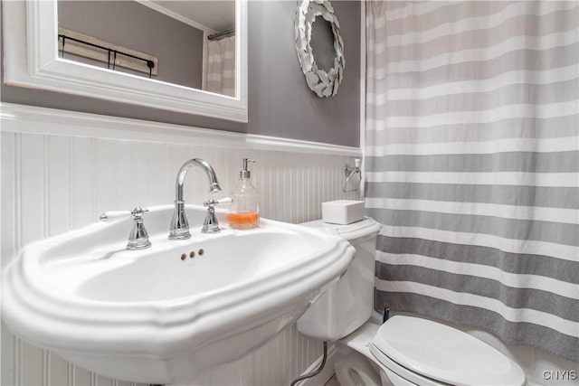 bathroom featuring sink, toilet, and ornamental molding