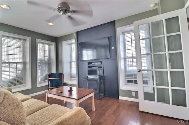 living room with ceiling fan and dark hardwood / wood-style flooring