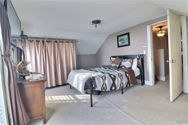 bedroom featuring vaulted ceiling and light colored carpet