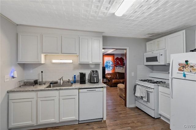 kitchen featuring tasteful backsplash, white appliances, dark wood-type flooring, sink, and white cabinetry