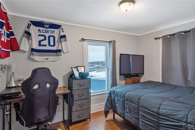 bedroom with hardwood / wood-style floors and crown molding