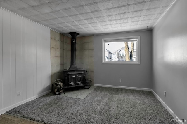 unfurnished living room with a wood stove, crown molding, and light colored carpet