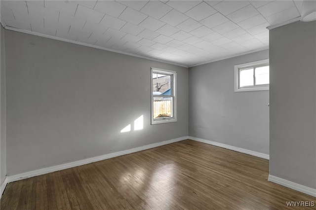 empty room with ornamental molding and hardwood / wood-style floors