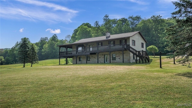 rear view of property featuring a wooden deck and a lawn