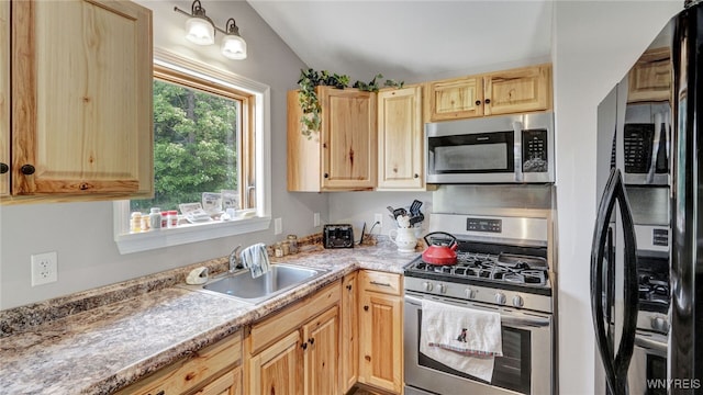 kitchen with stainless steel appliances, light brown cabinets, and sink