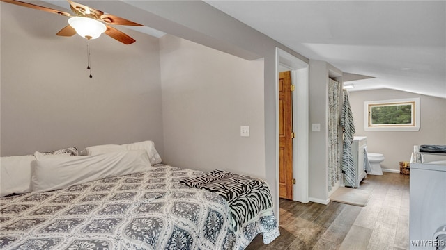 bedroom with hardwood / wood-style flooring, ensuite bath, ceiling fan, vaulted ceiling, and washer / clothes dryer