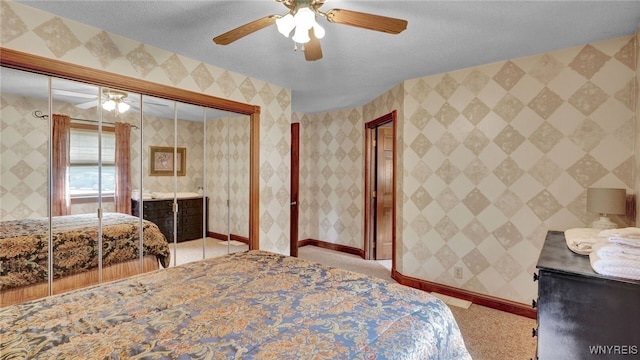 bedroom featuring light carpet, ceiling fan, and a textured ceiling