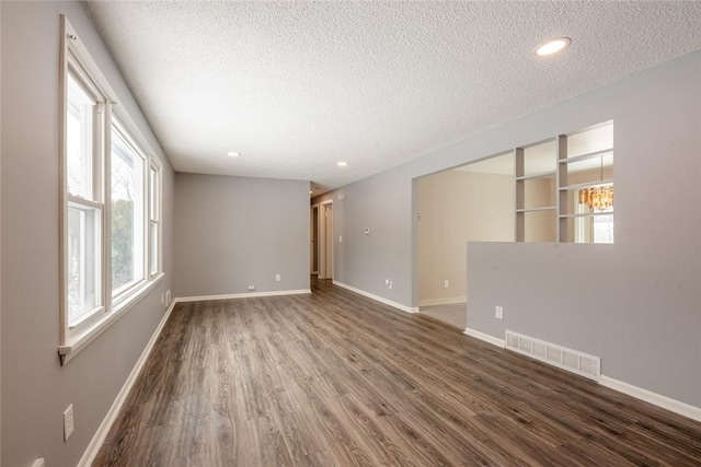 empty room featuring a textured ceiling and wood-type flooring