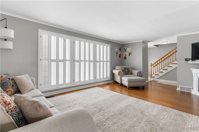 living room with hardwood / wood-style flooring and crown molding