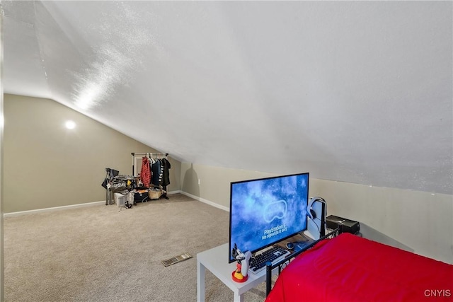 interior space with vaulted ceiling, carpet flooring, and a textured ceiling