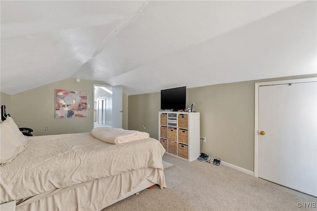 bedroom with light carpet and lofted ceiling