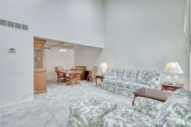 living room featuring a high ceiling, carpet flooring, and ceiling fan