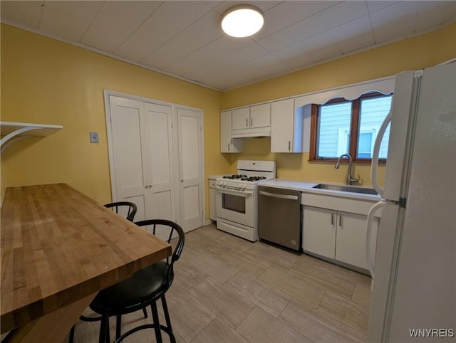 kitchen featuring sink, white appliances, and white cabinets