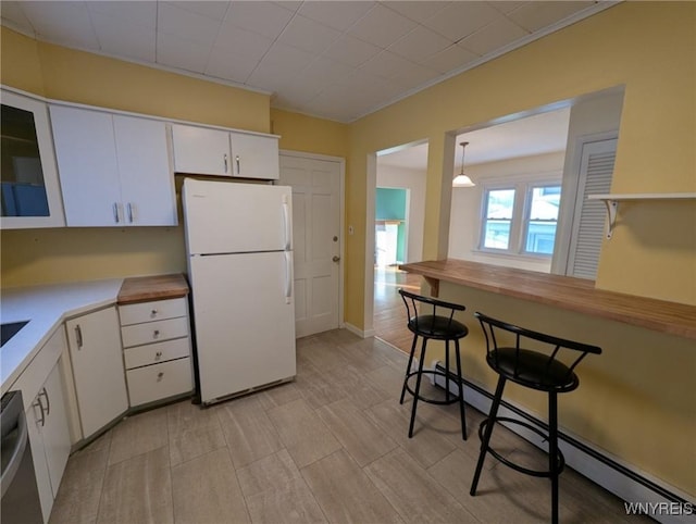 kitchen with stainless steel dishwasher, white fridge, white cabinetry, and pendant lighting