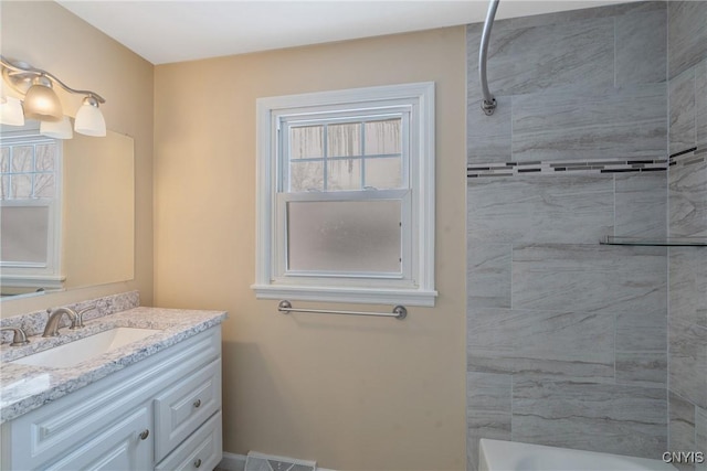 bathroom with vanity and tiled shower / bath