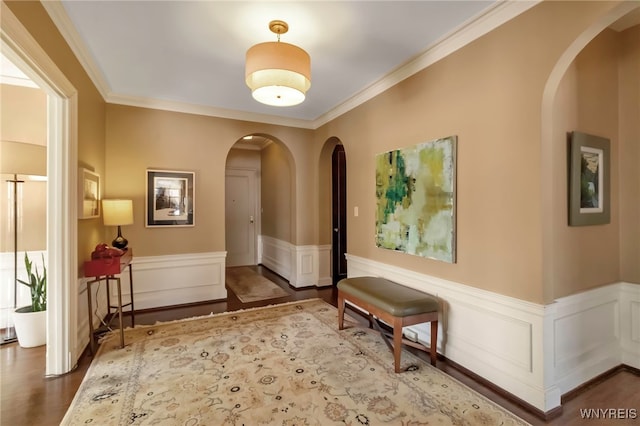 corridor with ornamental molding and hardwood / wood-style floors