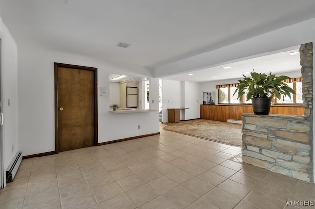 unfurnished living room featuring light tile patterned floors and a baseboard heating unit