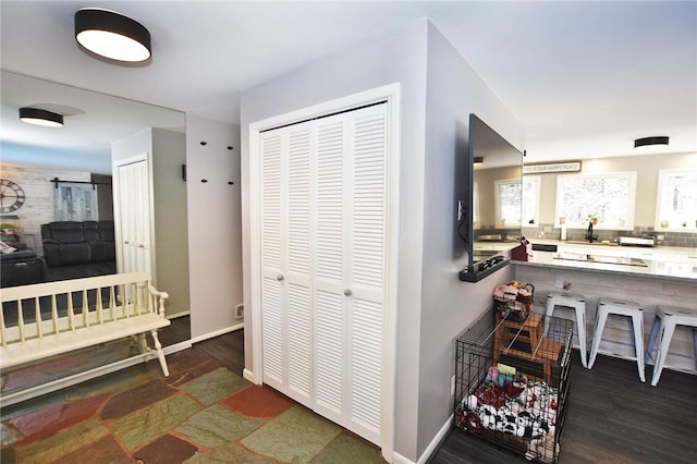 hall featuring baseboards and dark wood-type flooring