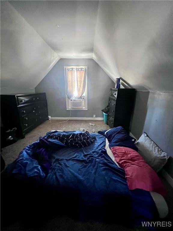 bedroom with carpet floors and lofted ceiling