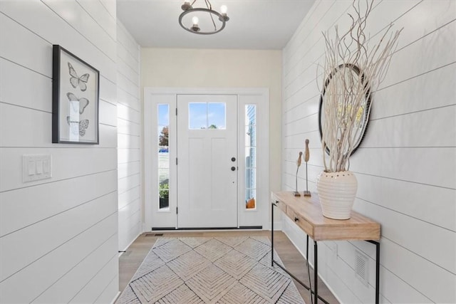 foyer entrance featuring light wood-type flooring and a notable chandelier