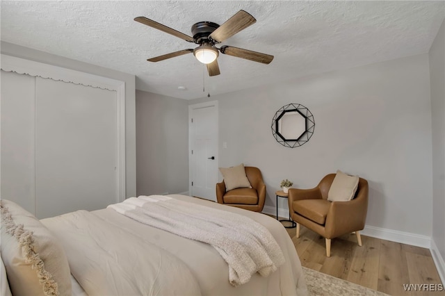 bedroom featuring a textured ceiling, ceiling fan, and light hardwood / wood-style flooring