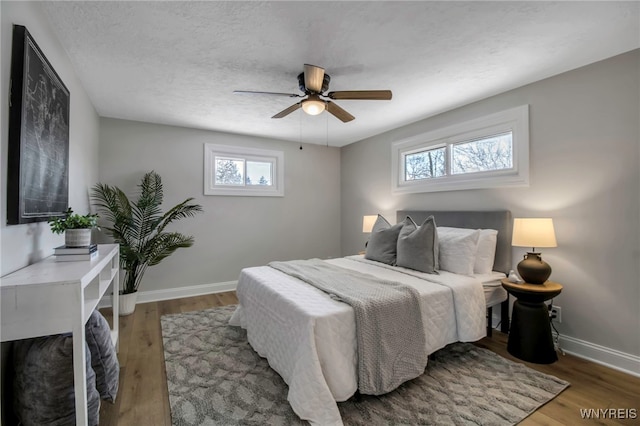 bedroom featuring hardwood / wood-style floors, ceiling fan, and a textured ceiling