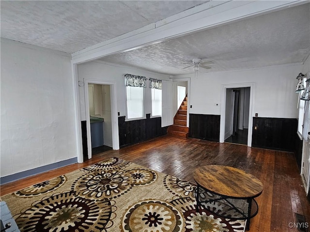 entryway with ceiling fan, dark wood-type flooring, beamed ceiling, and a textured ceiling