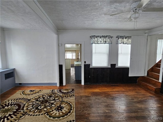 interior space featuring dark hardwood / wood-style flooring, ceiling fan, and a textured ceiling