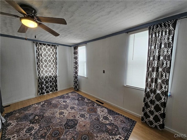 unfurnished room with light hardwood / wood-style floors and a textured ceiling