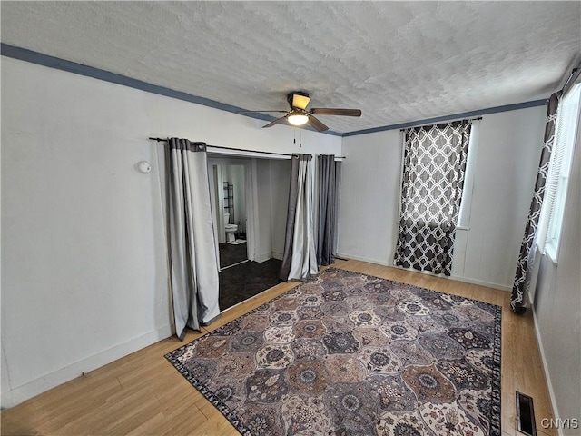 interior space featuring a textured ceiling, ceiling fan, and wood-type flooring