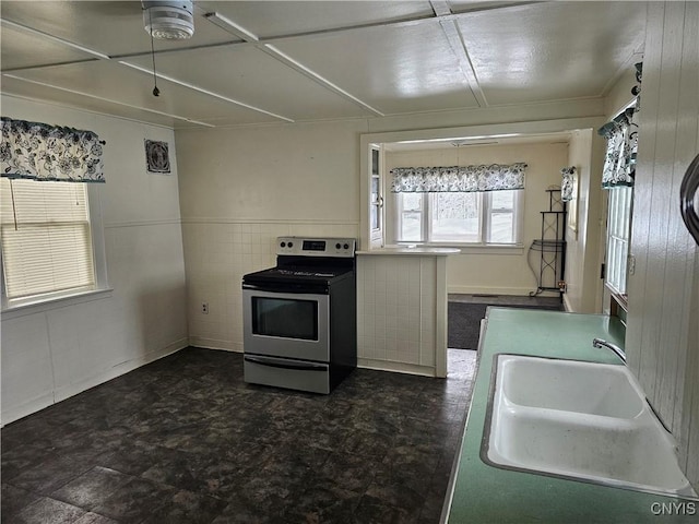 kitchen featuring tile walls, sink, and electric stove