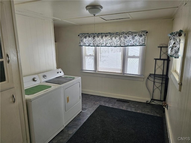 laundry area featuring washing machine and clothes dryer and wooden walls