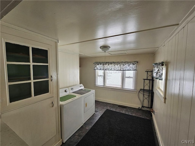 washroom with washer and dryer and wood walls