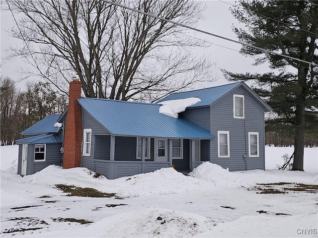 view of front facade with metal roof and a chimney