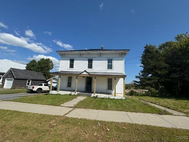 italianate home with covered porch and a front lawn