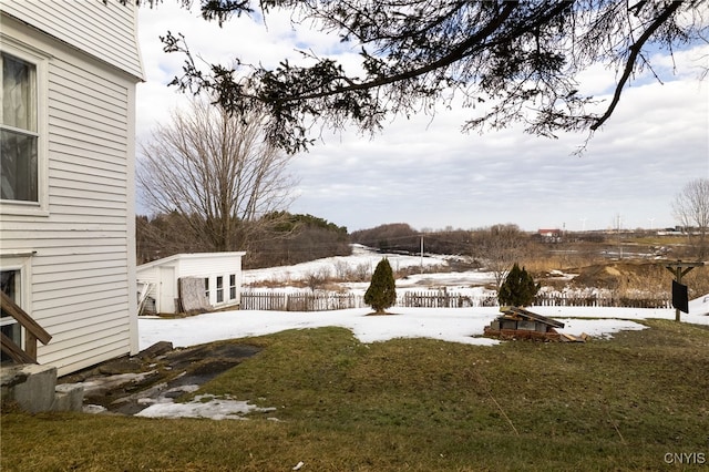 yard covered in snow featuring a storage unit