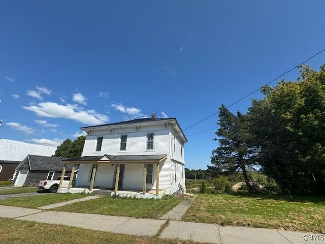 view of front of house with covered porch and a front yard