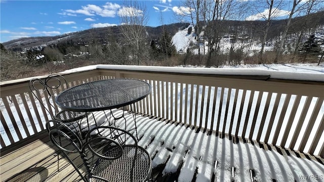 snow covered deck with a mountain view