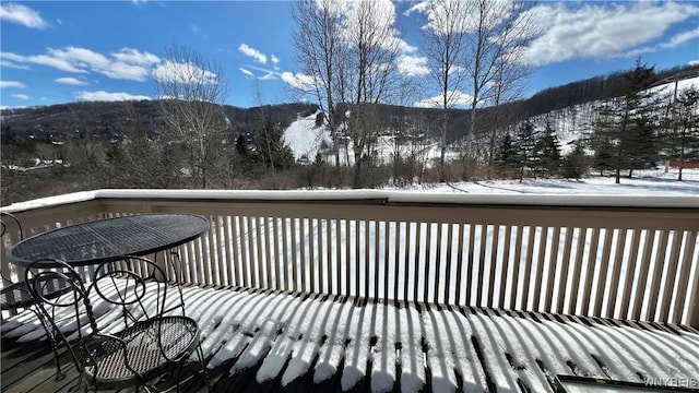 snow covered deck with a mountain view