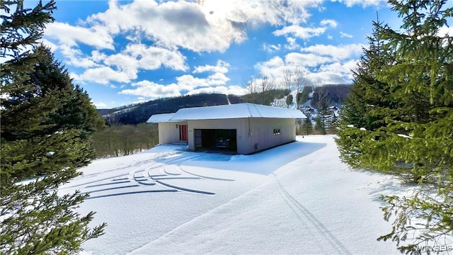 snow covered structure with a garage