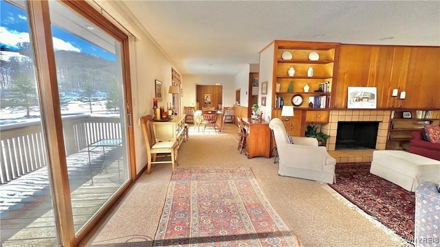 carpeted living room featuring a fireplace, built in features, a textured ceiling, and wooden walls