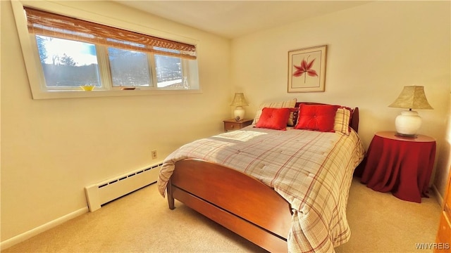 bedroom with a baseboard heating unit and light carpet