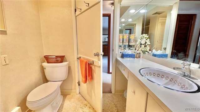 bathroom featuring toilet, vanity, and tile patterned flooring