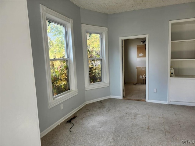 unfurnished room featuring light carpet and a textured ceiling