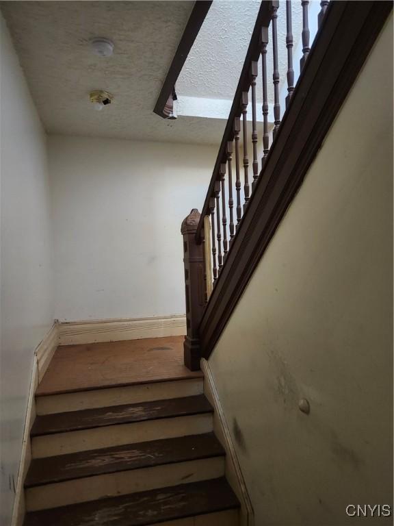 stairs with a textured ceiling