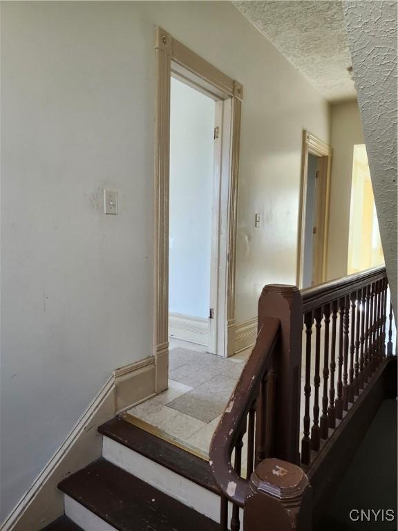 stairway with a textured ceiling