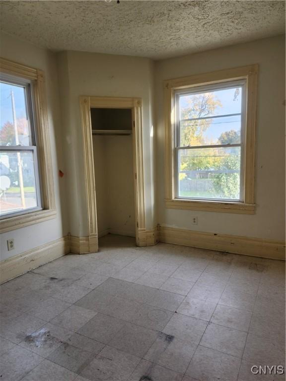 unfurnished bedroom featuring a textured ceiling and a closet