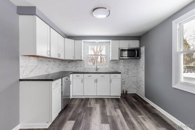 kitchen featuring white cabinetry, stainless steel appliances, tasteful backsplash, and sink