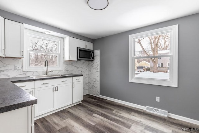 kitchen with sink, dark wood-type flooring, white cabinets, and tasteful backsplash